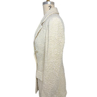 Left side profile of the authentic Chanel Cruise 2019 ivory fantasy tweed runway jacket illustrating the tailored fit and textured bouclé construction.