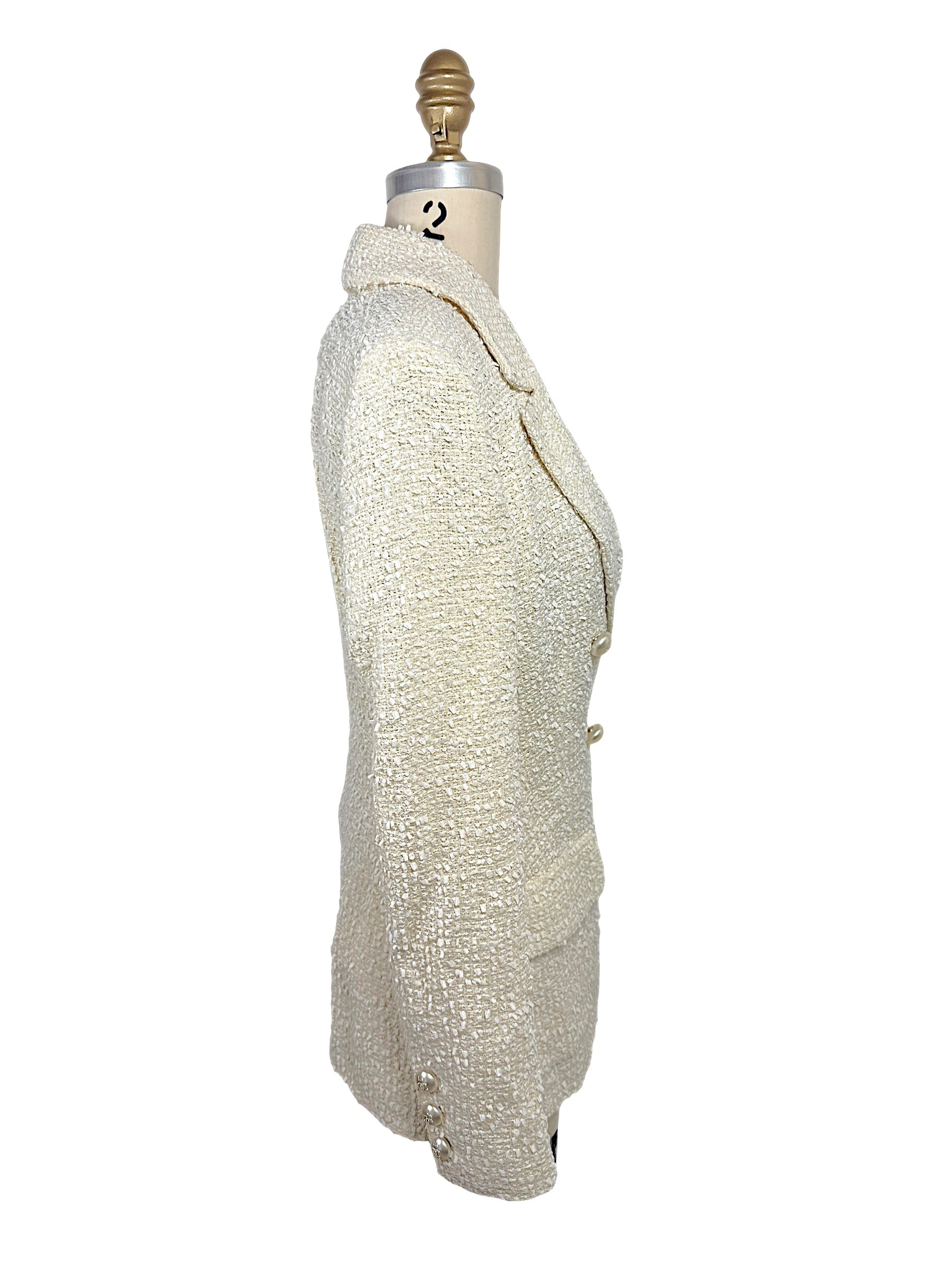 Right side profile of an authentic Chanel Cruise 2019 ivory fantasy tweed double-breasted runway jacket showing tailored construction and elegant silhouette.