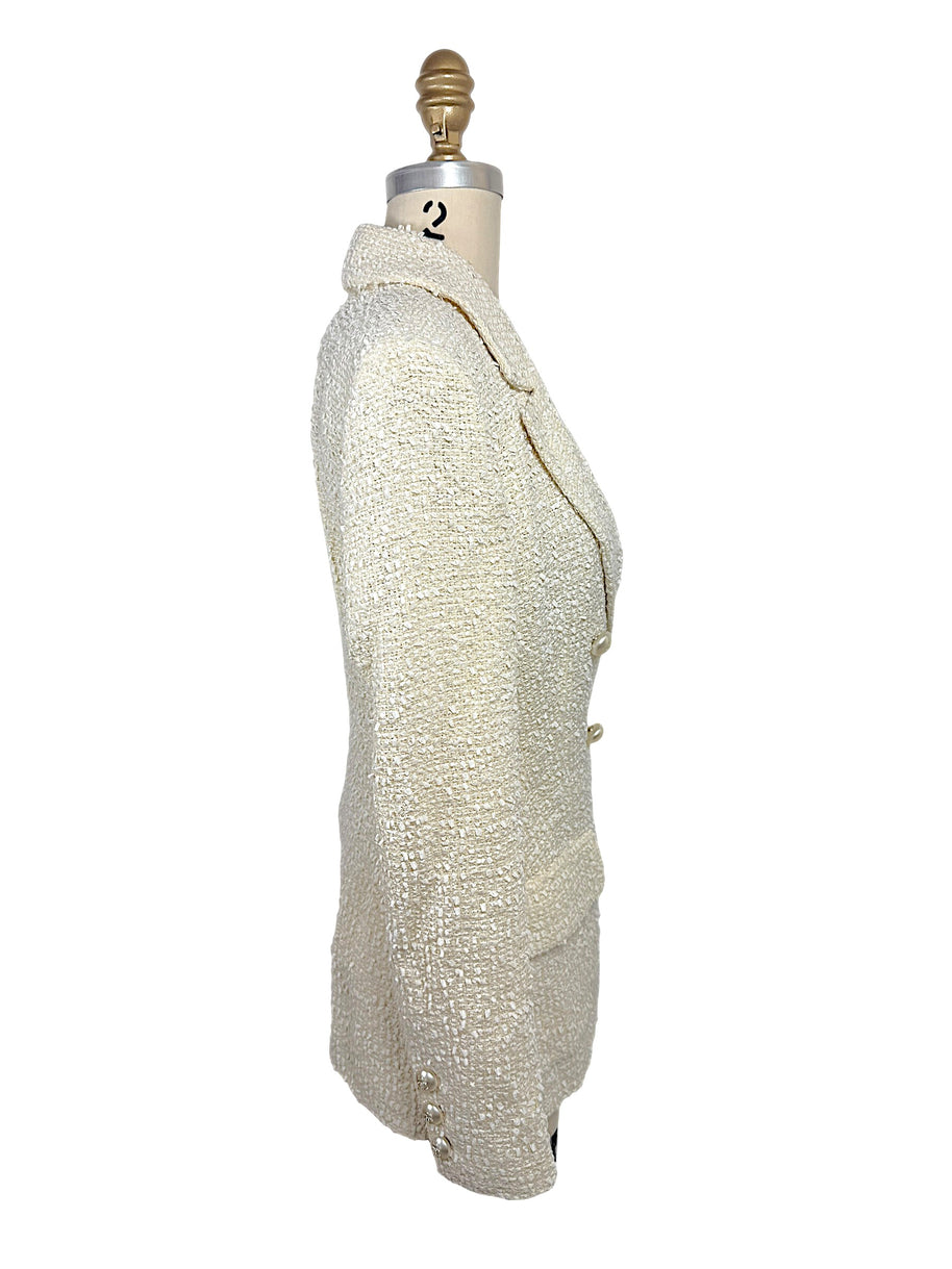 Right side profile of an authentic Chanel Cruise 2019 ivory fantasy tweed double-breasted runway jacket showing tailored construction and elegant silhouette.