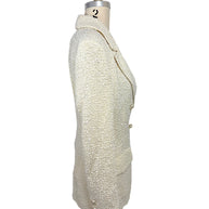 Right side profile of an authentic Chanel Cruise 2019 ivory fantasy tweed double-breasted runway jacket showing tailored construction and elegant silhouette.