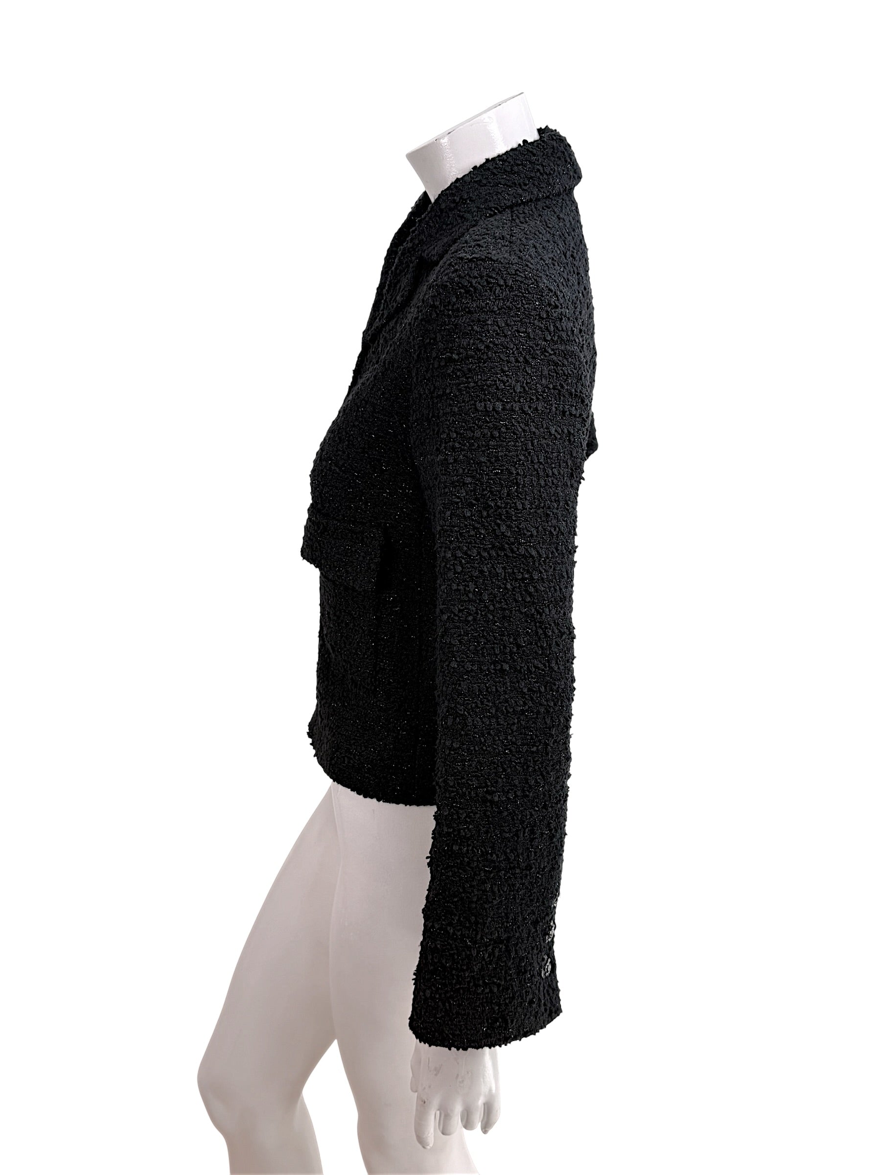 Side profile of Chanel Cruise 2021 black bouclé tweed jacket with tailored cropped fit and textured bouclé finish