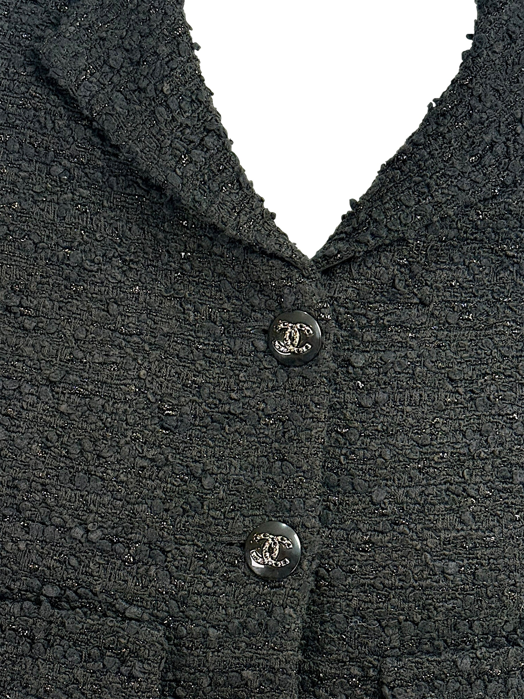 Detailed close-up of textured black bouclé tweed fabrication on Chanel Cruise 2021 runway jacket