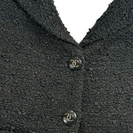 Detailed close-up of textured black bouclé tweed fabrication on Chanel Cruise 2021 runway jacket