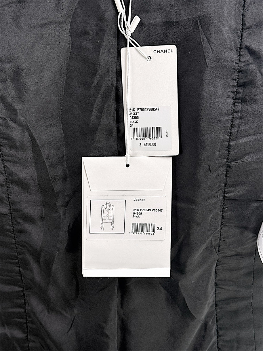 Close-up of original Chanel Cruise 2021 boutique retail tags attached to black bouclé tweed jacket