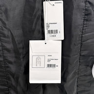 Close-up of original Chanel Cruise 2021 boutique retail tags attached to black bouclé tweed jacket