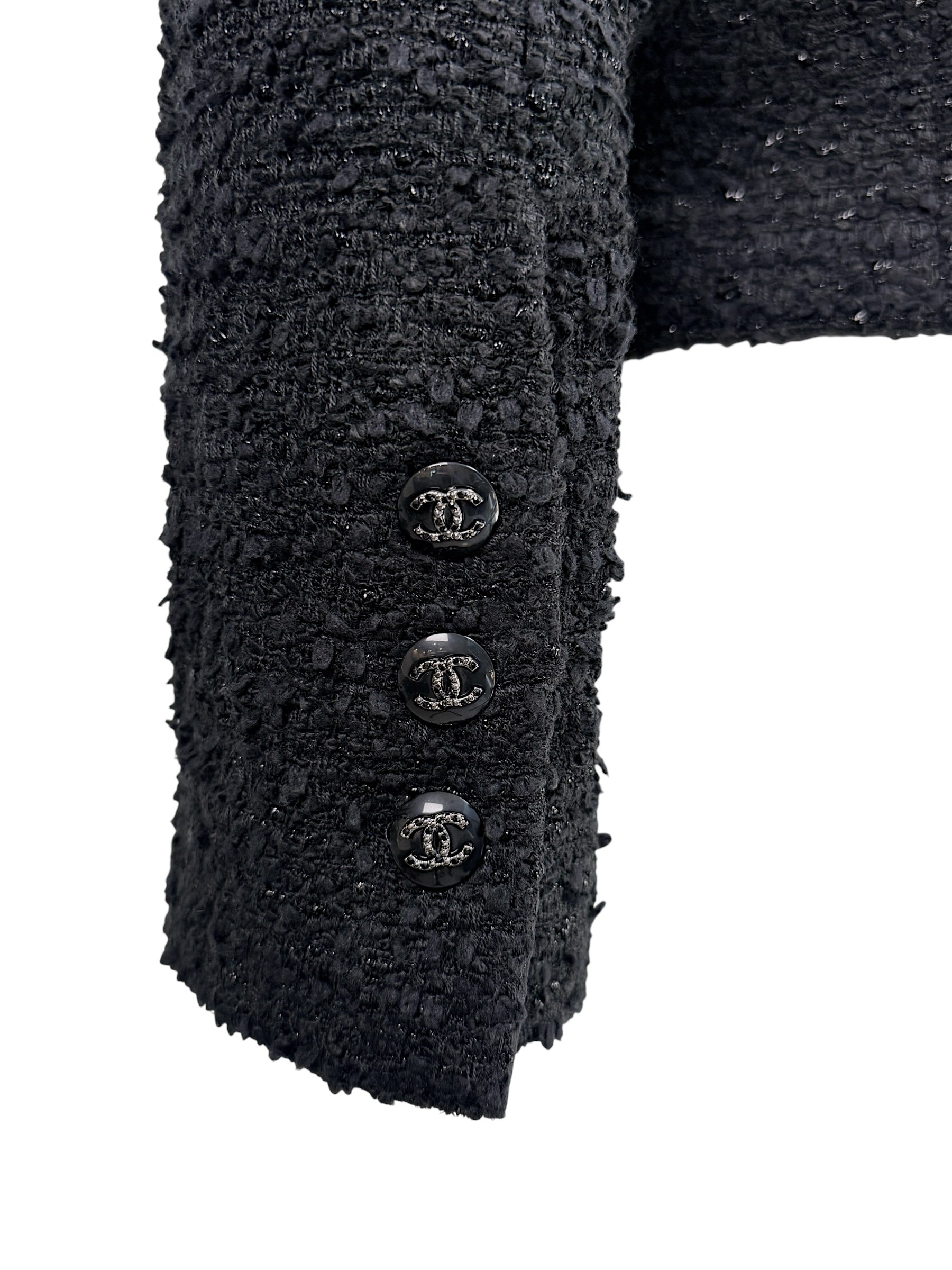 Detail image of Chanel Cruise 2021 jacket cuff featuring signature black CC logo buttons