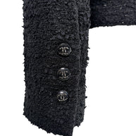 Detail image of Chanel Cruise 2021 jacket cuff featuring signature black CC logo buttons