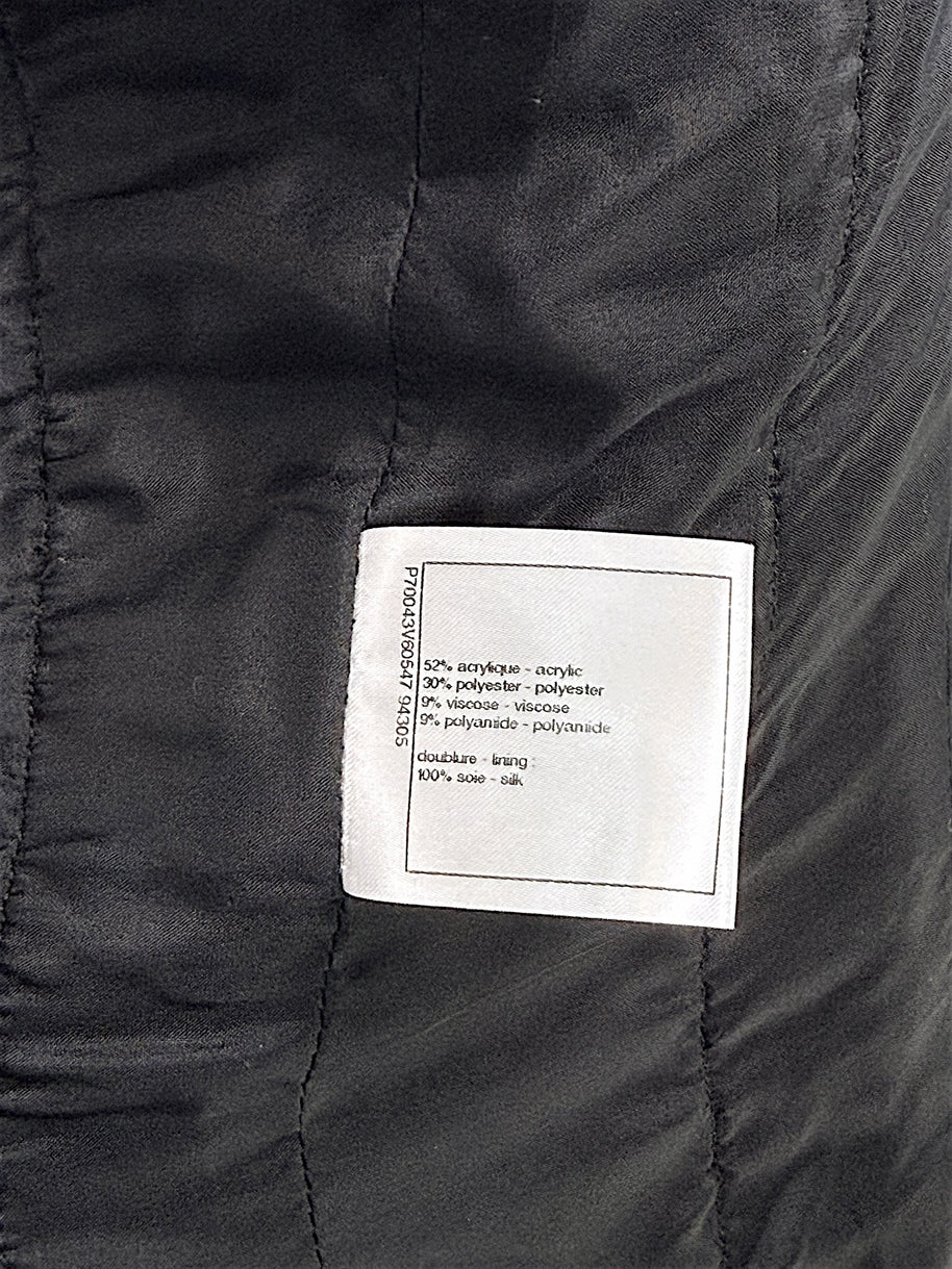 Fabric composition label inside Chanel Cruise 2021 black bouclé tweed jacket with silk lining