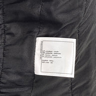 Fabric composition label inside Chanel Cruise 2021 black bouclé tweed jacket with silk lining