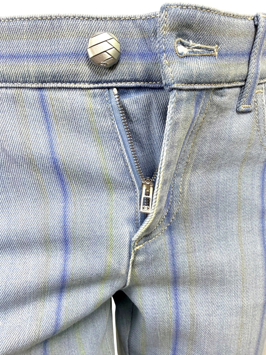 Detail image of Chanel striped denim jeans zip fly closure with engraved hardware and light blue denim finish.