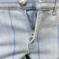 Detail image of Chanel striped denim jeans zip fly closure with engraved hardware and light blue denim finish.