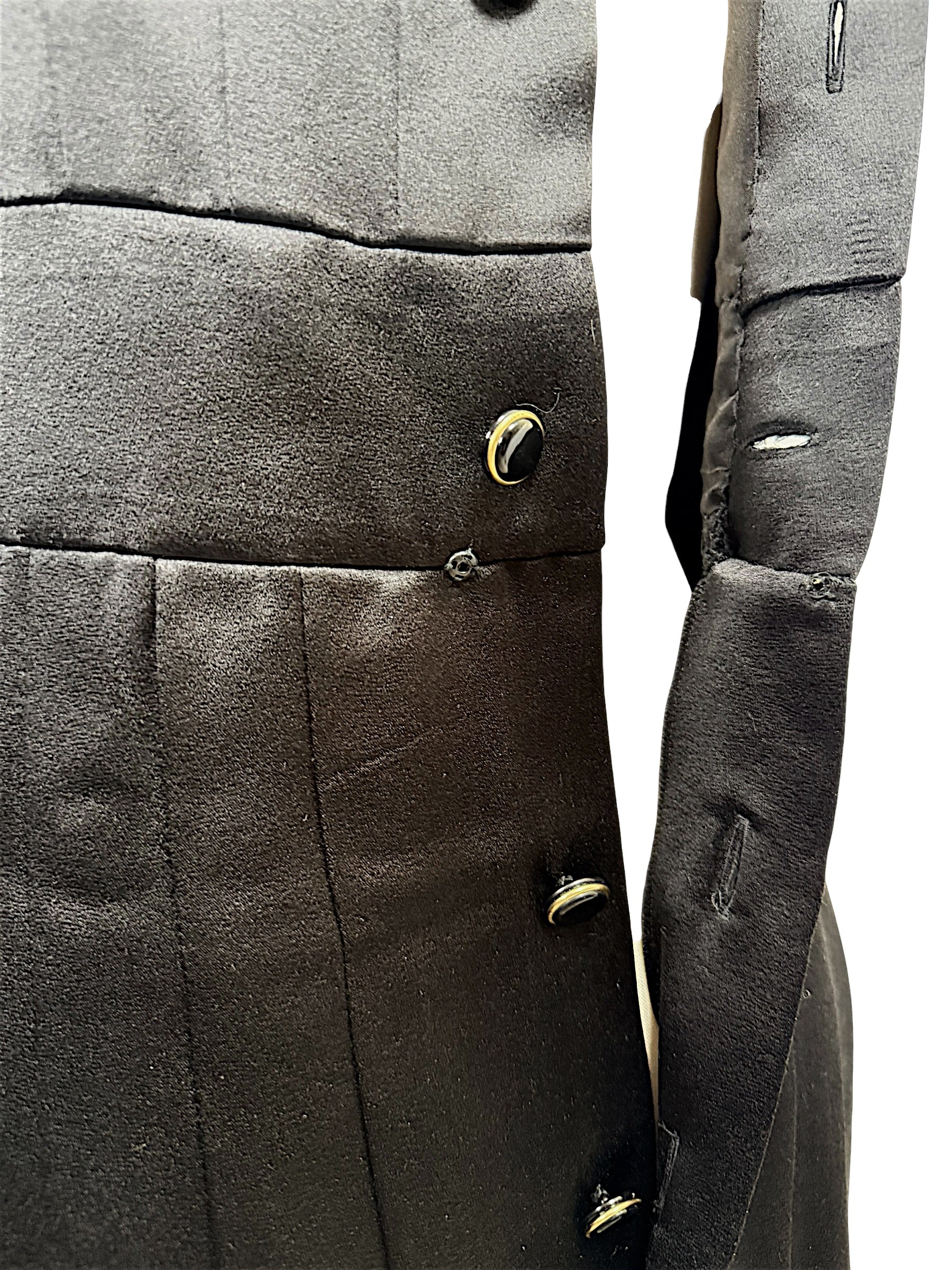 Close-up condition detail of vintage Chanel black satin dress showing minor pulls consistent with age and use.