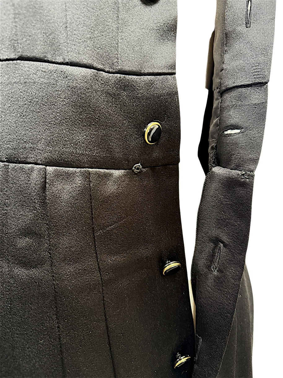 Close-up condition detail of vintage Chanel black satin dress showing minor pulls consistent with age and use.
