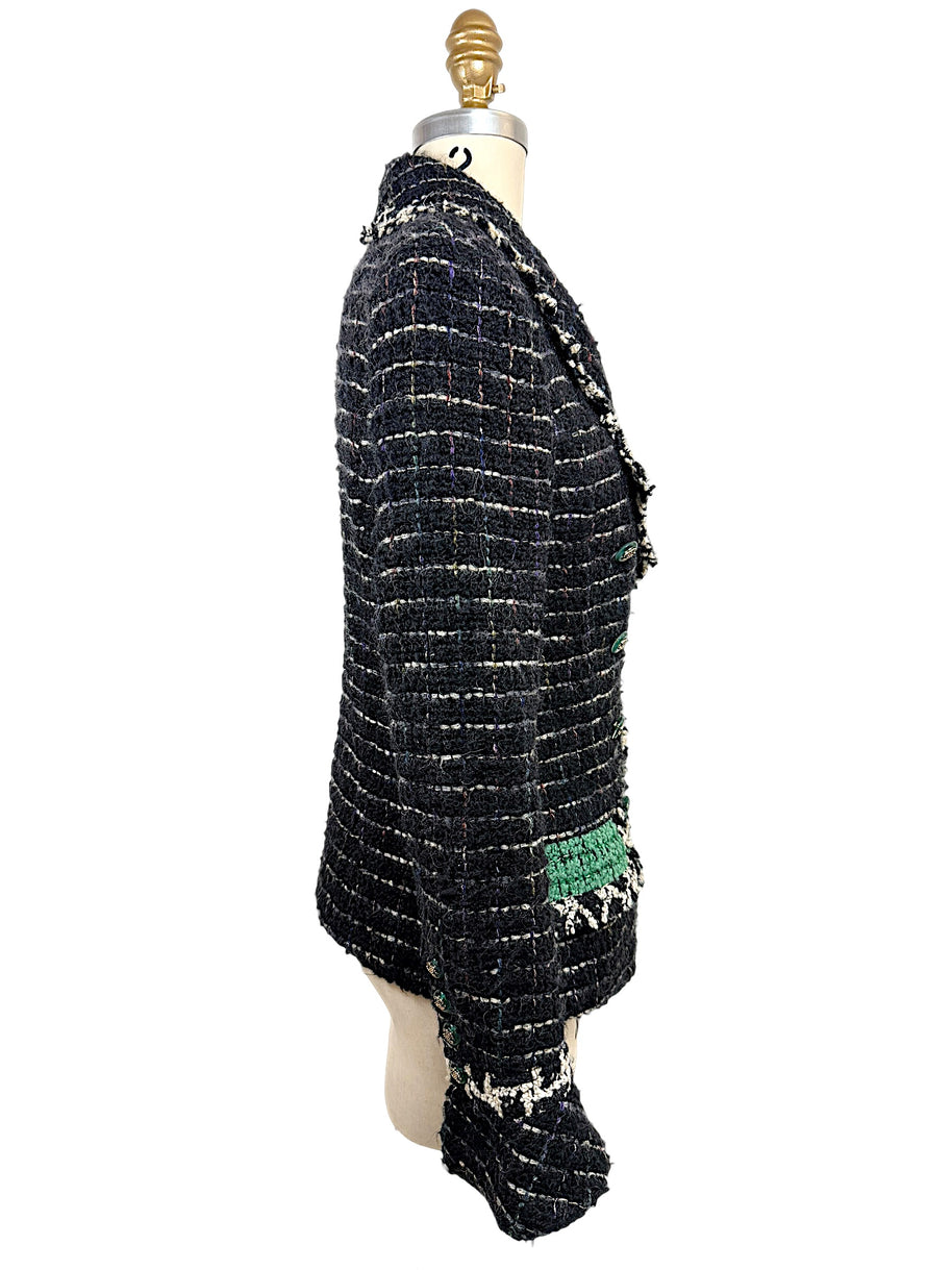 Left side profile of the Chanel Fall 2009 Runway Look 22 bouclé tweed jacket highlighting its tailored silhouette, emerald cuff accent, and textured weave.