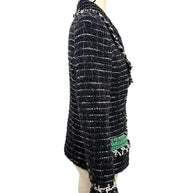 Left side profile of the Chanel Fall 2009 Runway Look 22 bouclé tweed jacket highlighting its tailored silhouette, emerald cuff accent, and textured weave.