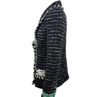 Right side profile of the Chanel Fall 2009 Runway Look 22 black bouclé tweed jacket featuring ivory fringe trim, emerald cuff detail, and signature Chanel tailoring.