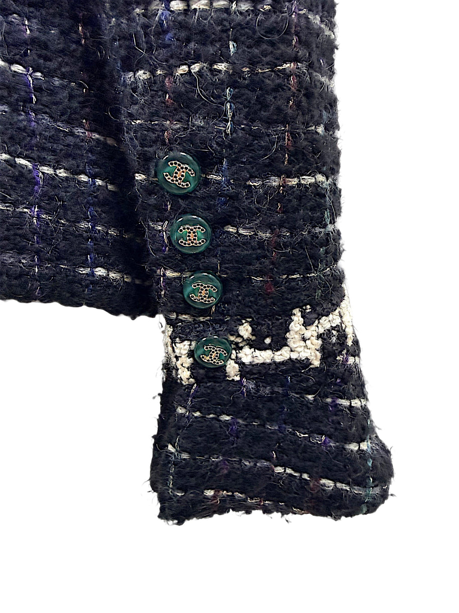 Close-up of Chanel emerald enamel CC logo buttons and textured bouclé cuff from the Fall 2009 Runway Look 22 jacket.