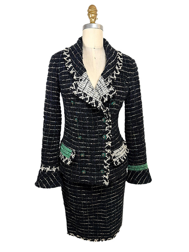 Front view of Chanel Fall 2009 Runway Look 22 black bouclé tweed jacket and matching skirt featuring ivory fringe trim, emerald green accents, and signature CC buttons.