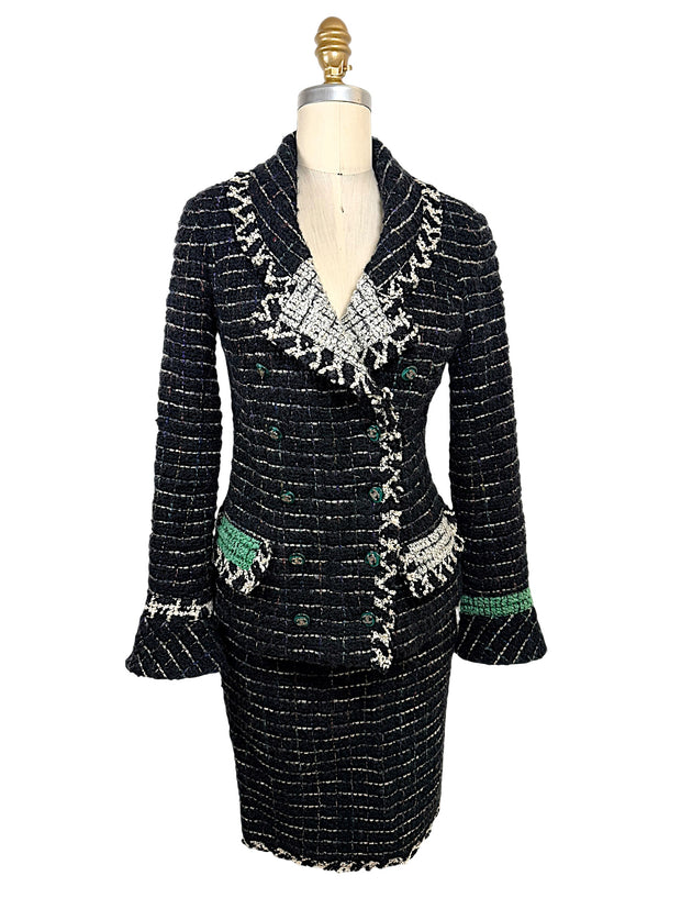 Front view of Chanel Fall 2009 Runway Look 22 black bouclé tweed jacket and matching skirt featuring ivory fringe trim, emerald green accents, and signature CC buttons.