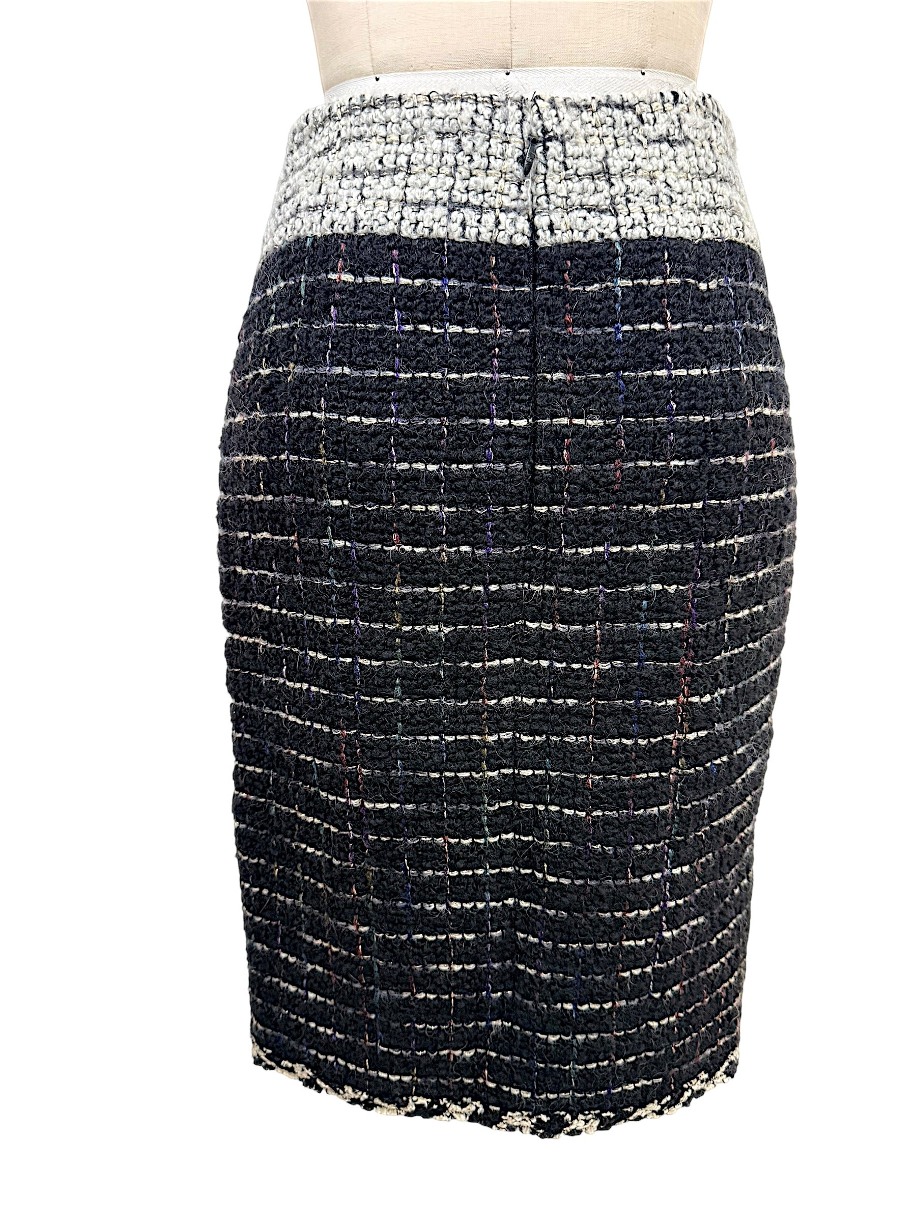 Rear view of the Chanel Fall 2009 Runway Look 22 black bouclé tweed pencil skirt with contrasting ivory waistband and streamlined tailoring.