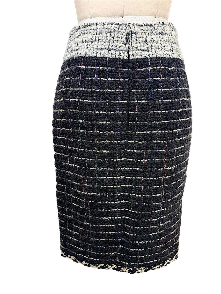 Rear view of the Chanel Fall 2009 Runway Look 22 black bouclé tweed pencil skirt with contrasting ivory waistband and streamlined tailoring.