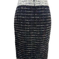 Rear view of the Chanel Fall 2009 Runway Look 22 black bouclé tweed pencil skirt with contrasting ivory waistband and streamlined tailoring.