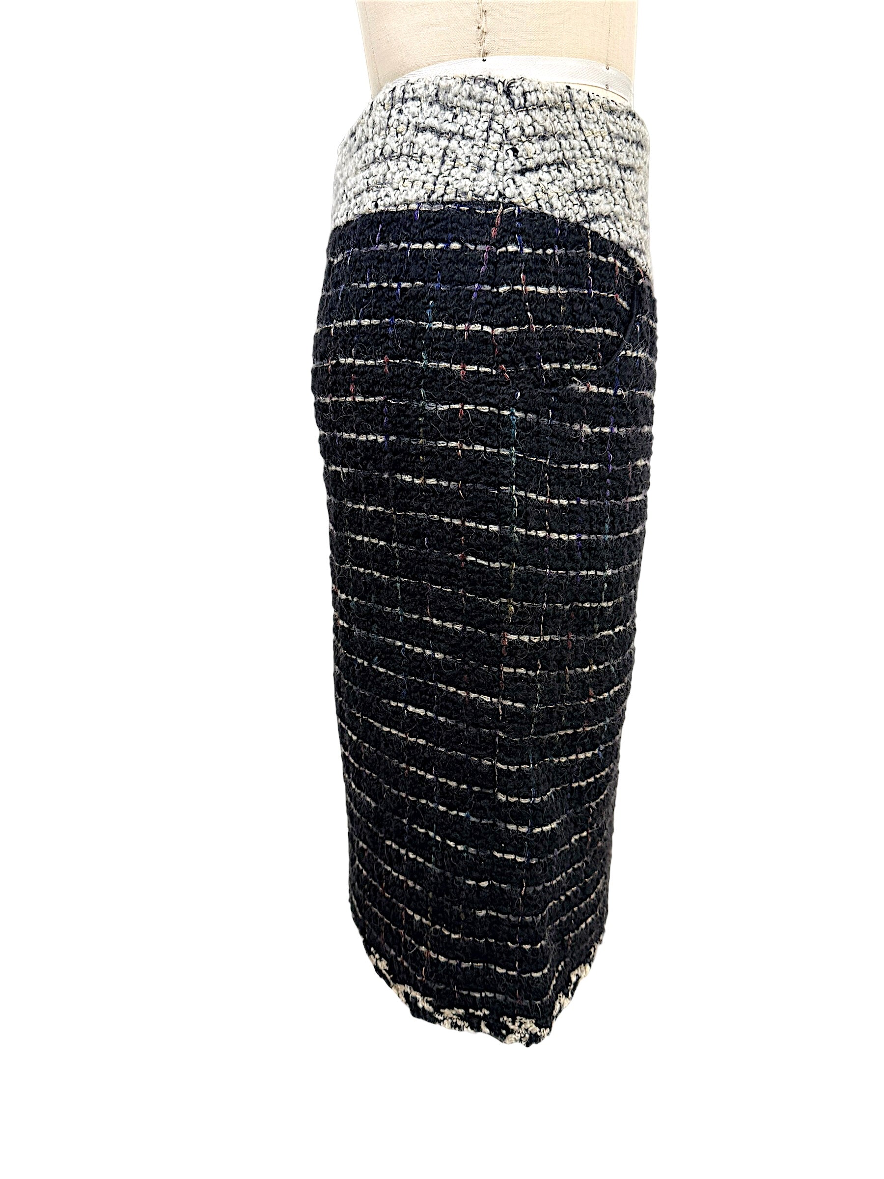 Side profile of the Chanel Fall 2009 Runway Look 22 black bouclé tweed pencil skirt featuring an ivory textured waistband and tailored silhouette.