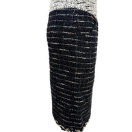 Side profile of the Chanel Fall 2009 Runway Look 22 black bouclé tweed pencil skirt featuring an ivory textured waistband and tailored silhouette.