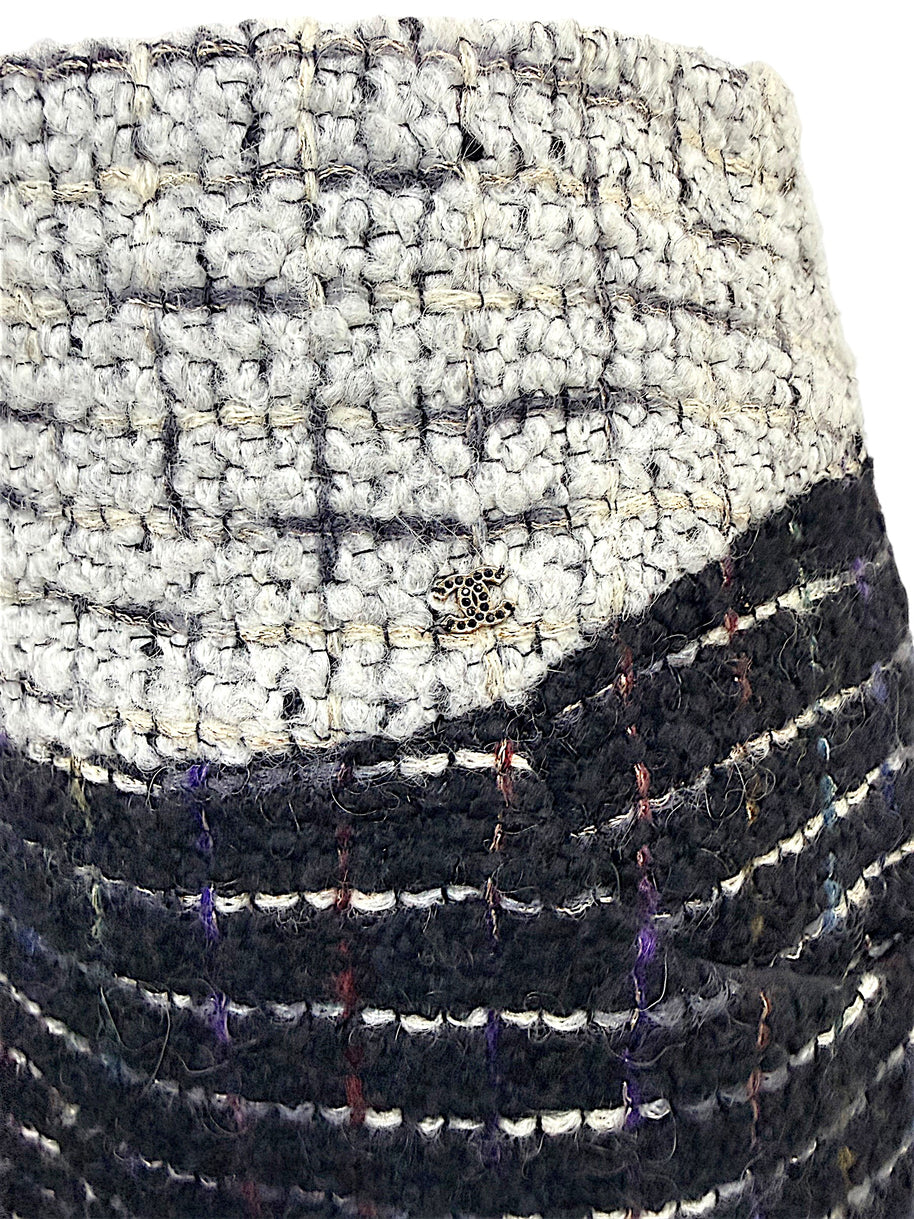 Close-up of the discreet Chanel CC logo hardware at the ivory bouclé waistband on the Fall 2009 Runway Look 22 skirt.