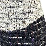 Close-up of the discreet Chanel CC logo hardware at the ivory bouclé waistband on the Fall 2009 Runway Look 22 skirt.