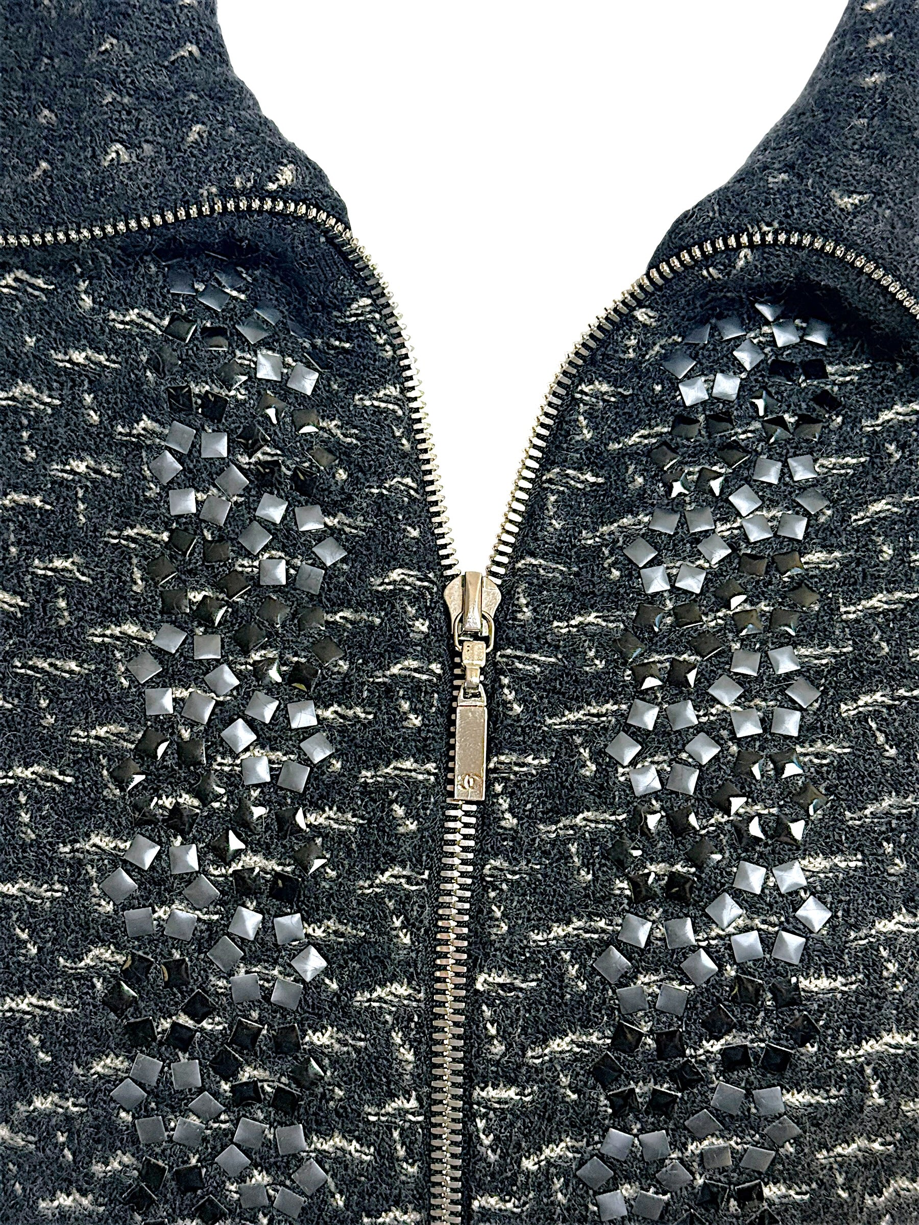 Detailed close-up of Chanel Fall Winter 2010 appliqué embellishment and front zip closure