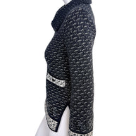 Side profile detail of Chanel Fall Winter 2010 appliqué tweed jacket with slit hem