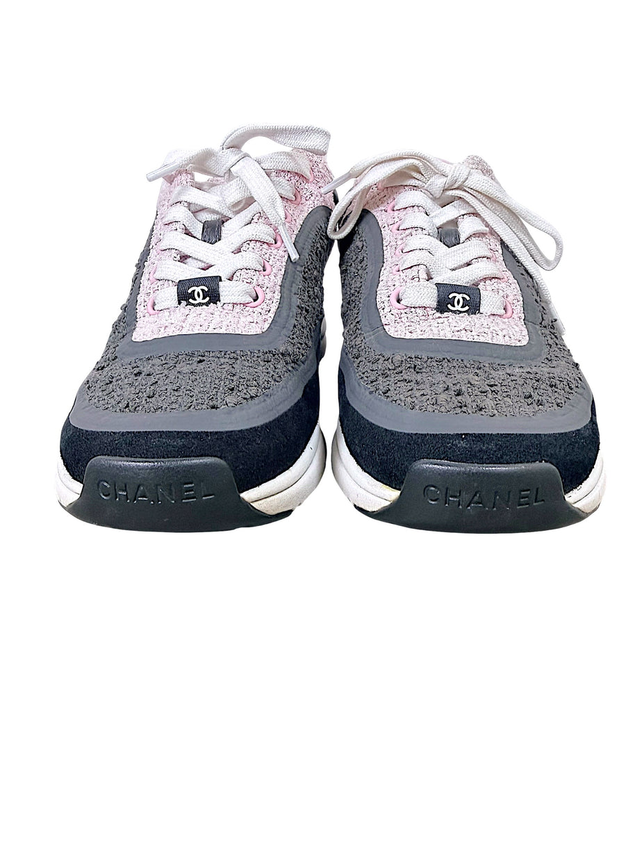 Front view of Chanel pink and grey tweed sneakers with CC lace tabs and Chanel toe branding