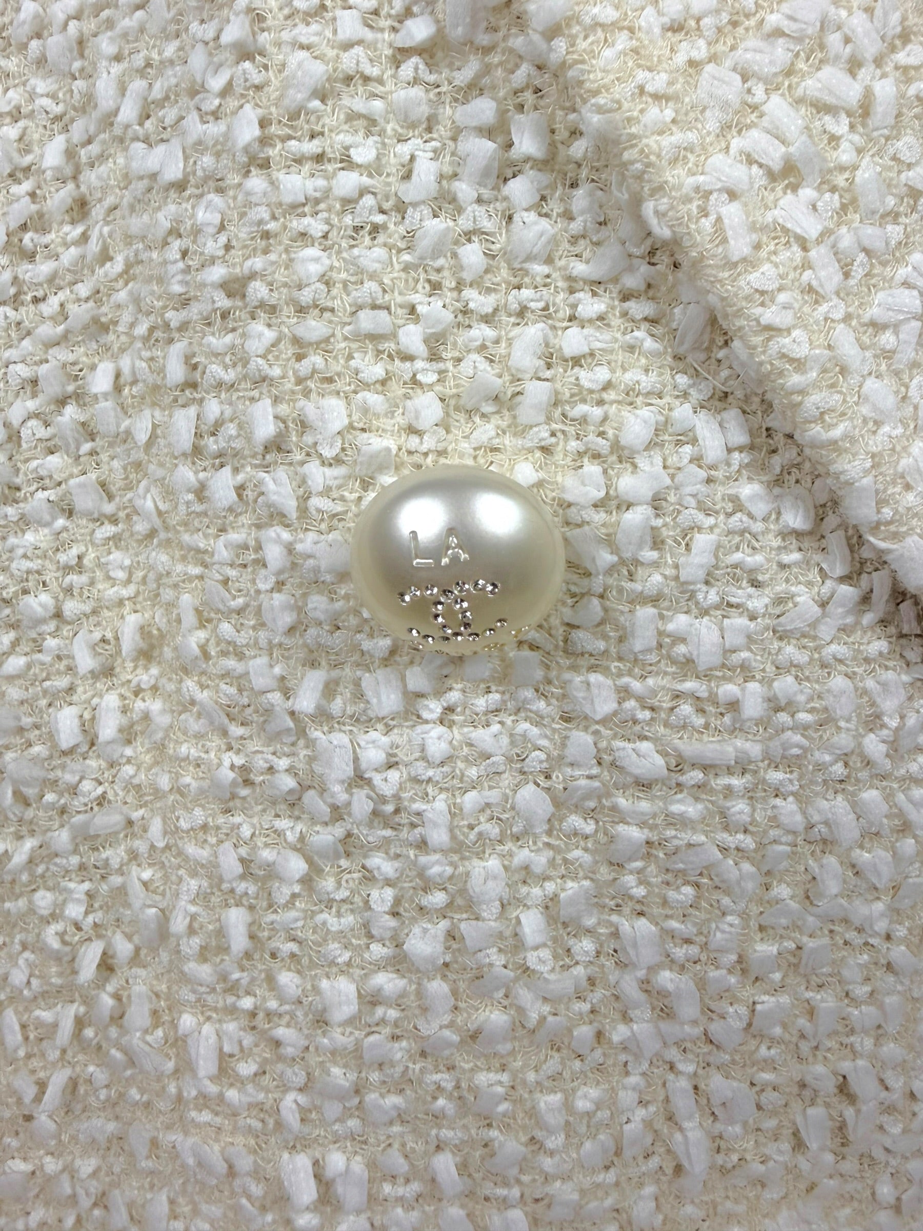 Close-up of the original pearl-effect Chanel CC button engraved 