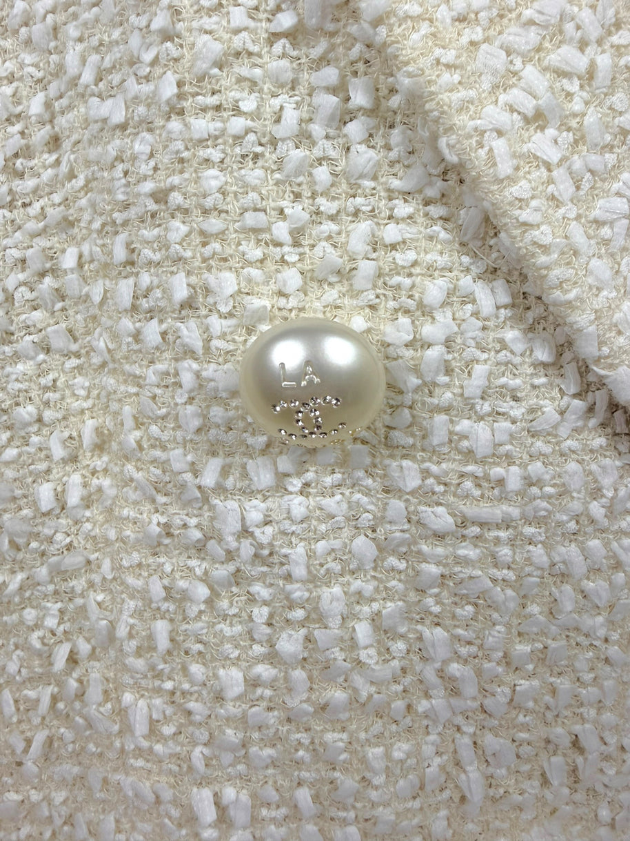 Close-up of the original pearl-effect Chanel CC button engraved 