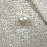 Close-up of the original pearl-effect Chanel CC button engraved 
