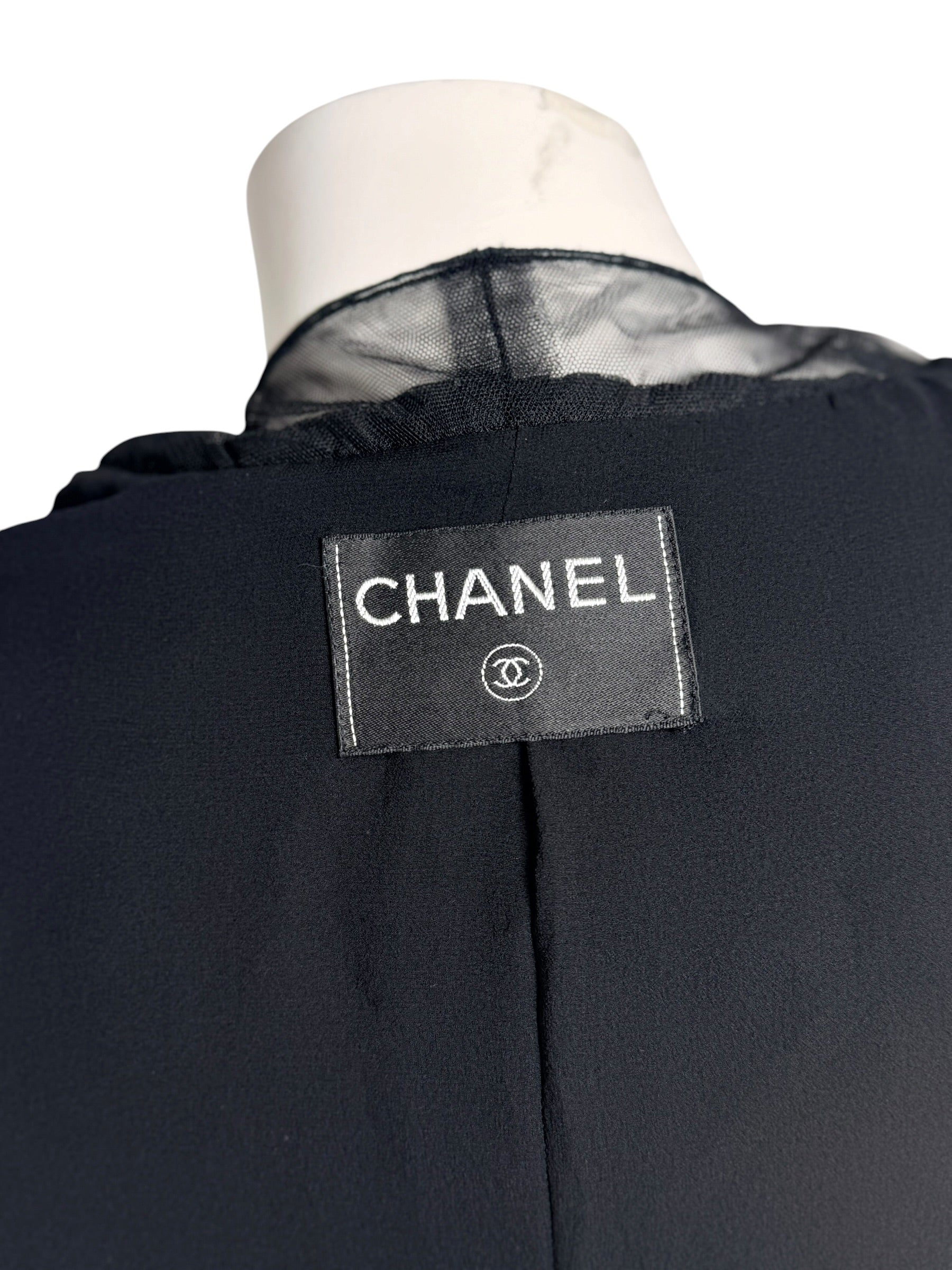 Interior Chanel logo label on black cropped bolero jacket with silk chiffon trim