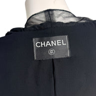 Interior Chanel logo label on black cropped bolero jacket with silk chiffon trim