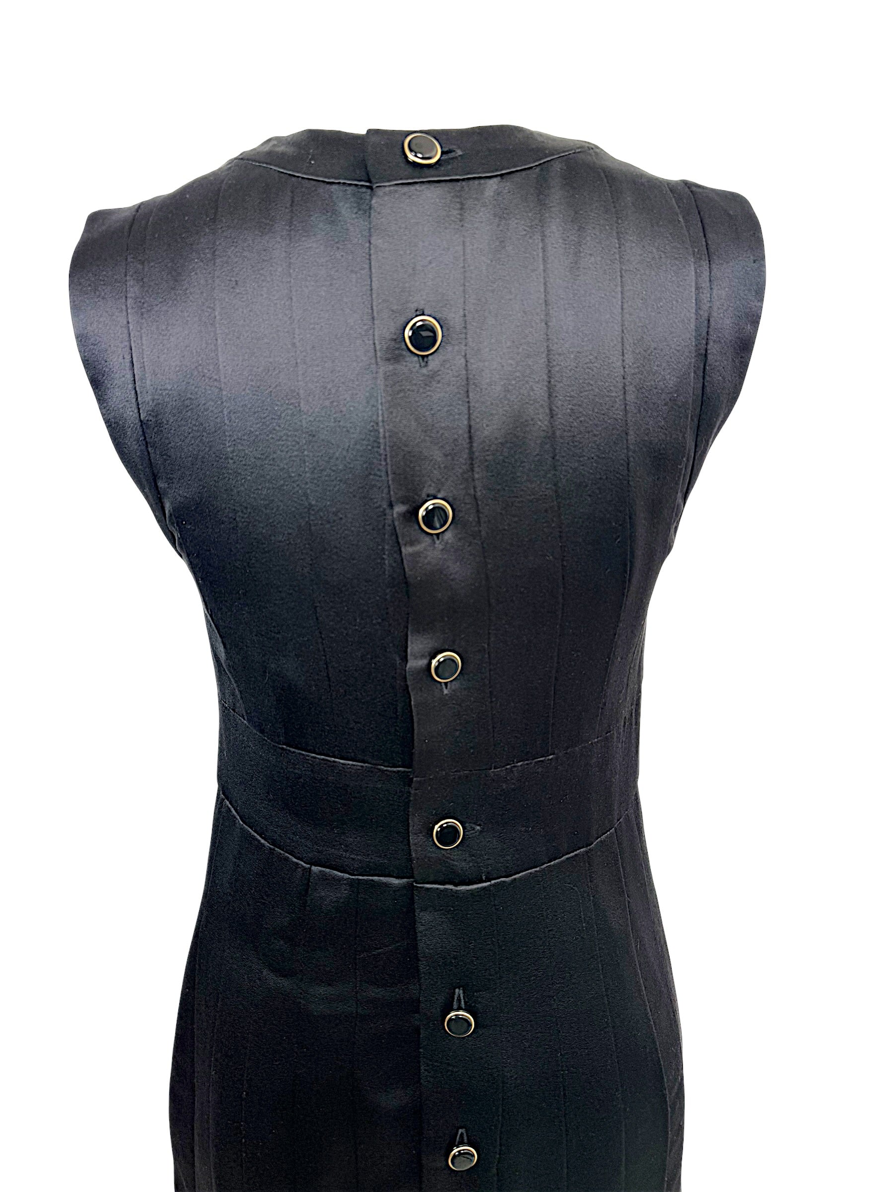 Close-up rear detail of Chanel black satin dress with black enamel and gold-tone logo buttons.