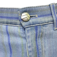 Close-up of Chanel engraved silver logo button on pale blue striped denim jeans from Spring 2006 collection.