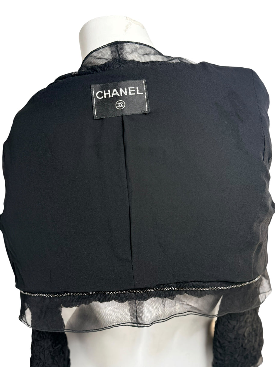Close-up of Chanel label stitched inside black cropped ruched bolero jacket
