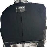 Close-up of Chanel label stitched inside black cropped ruched bolero jacket