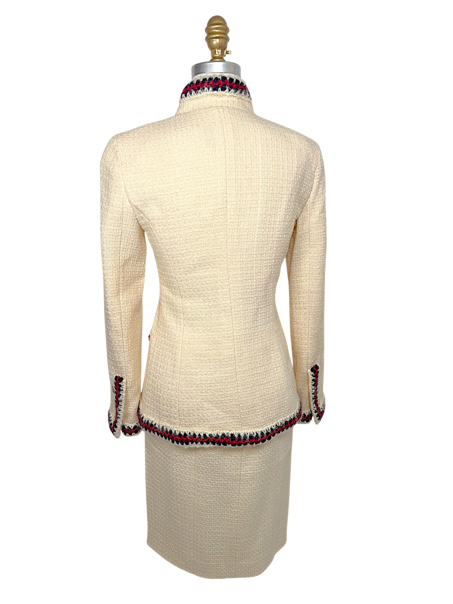 Rear view of Chanel Pre-Fall 2010 ivory bouclé jacket showcasing clean tailored construction and signature braided trim along the collar and hem.