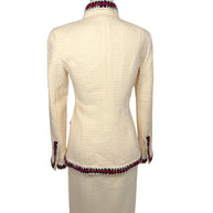 Rear view of Chanel Pre-Fall 2010 ivory bouclé jacket showcasing clean tailored construction and signature braided trim along the collar and hem.