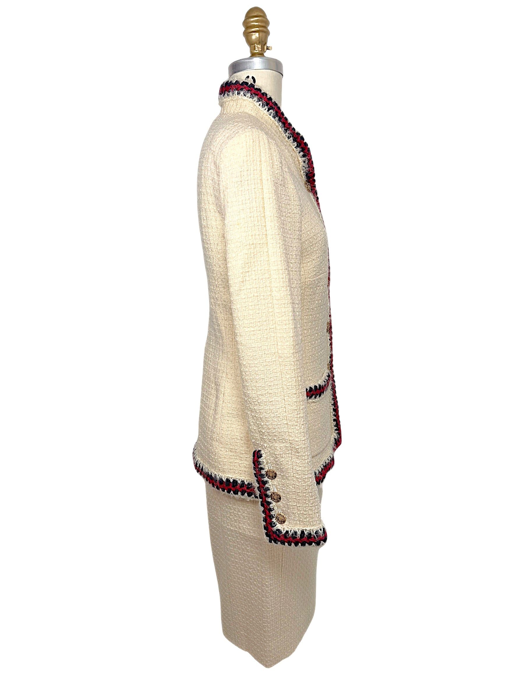 Side profile of Chanel Pre-Fall 2010 ivory bouclé jacket showing structured tailoring and braided trim extending around the hem and cuffs.