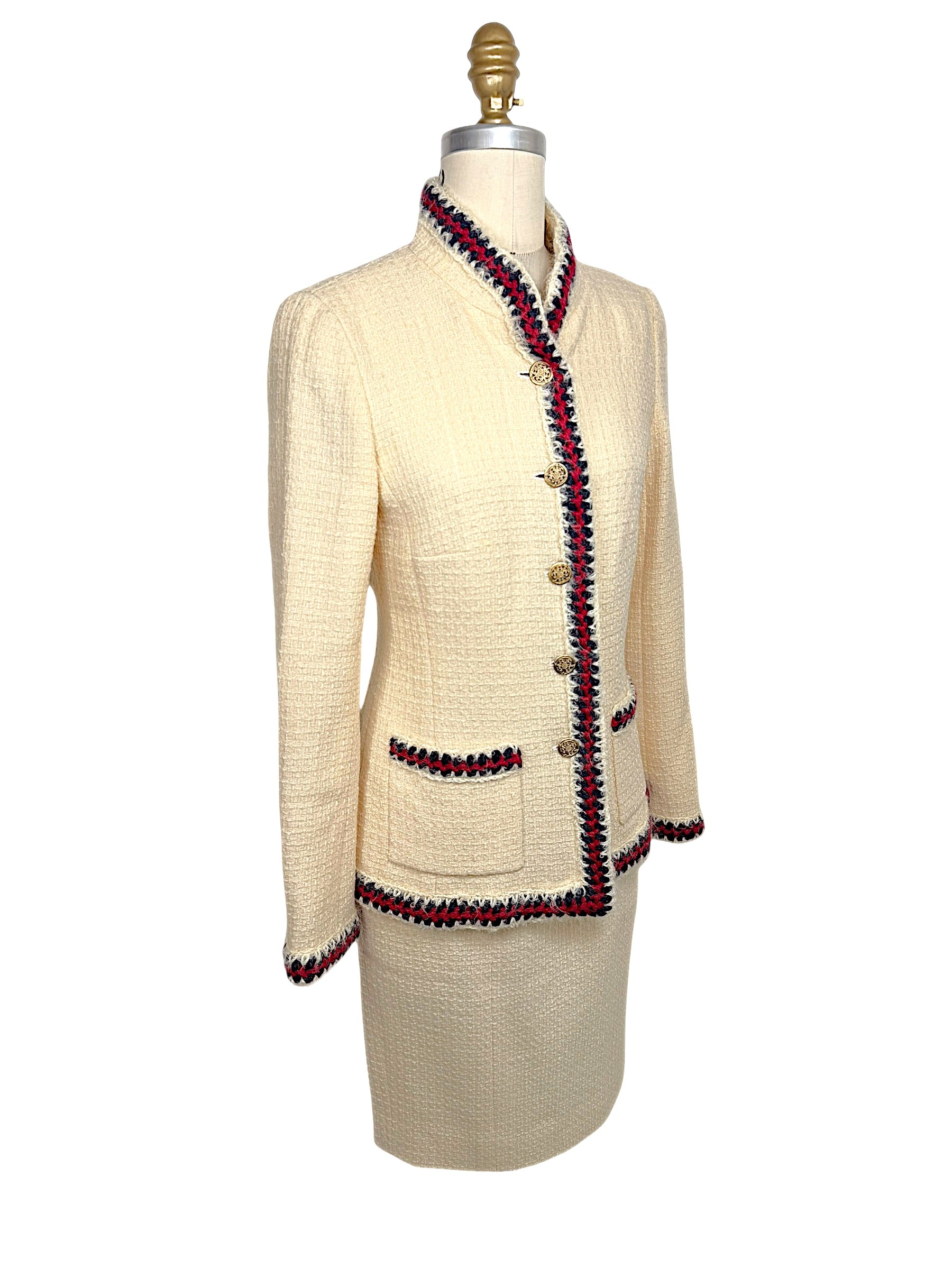 Three-quarter front view of Chanel Pre-Fall 2010 ivory bouclé jacket highlighting tailored silhouette and braided trim detailing.