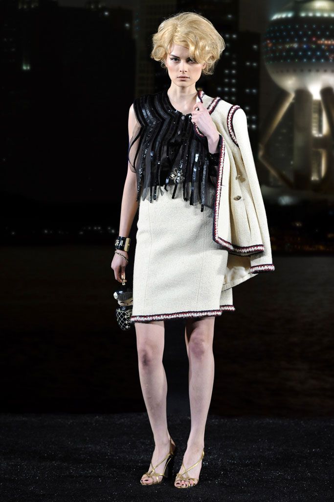 Documented Chanel Pre-Fall 2010 Paris-Shanghai Métiers d'Art Runway Look 42 featuring an ivory bouclé skirt suit with signature braided trim designed by Karl Lagerfeld.