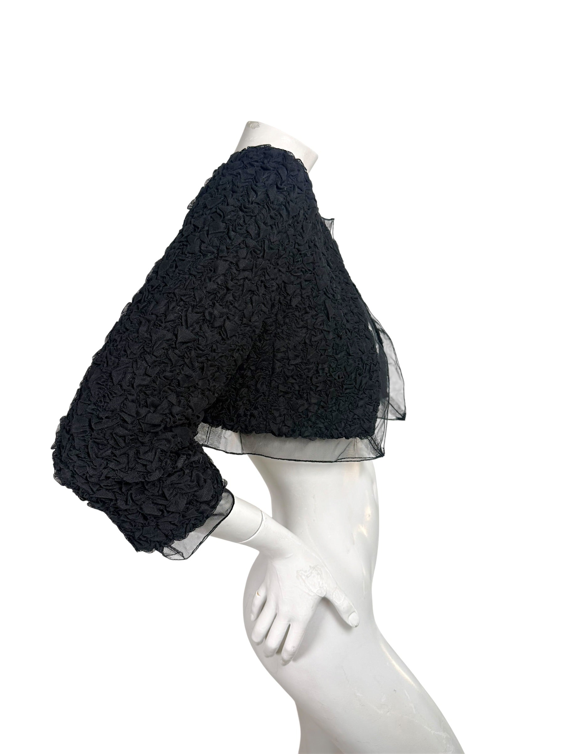 Right side view of Chanel black cropped bolero jacket with textured ruched fabric and sheer sleeve
