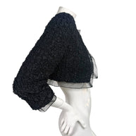 Right side view of Chanel black cropped bolero jacket with textured ruched fabric and sheer sleeve