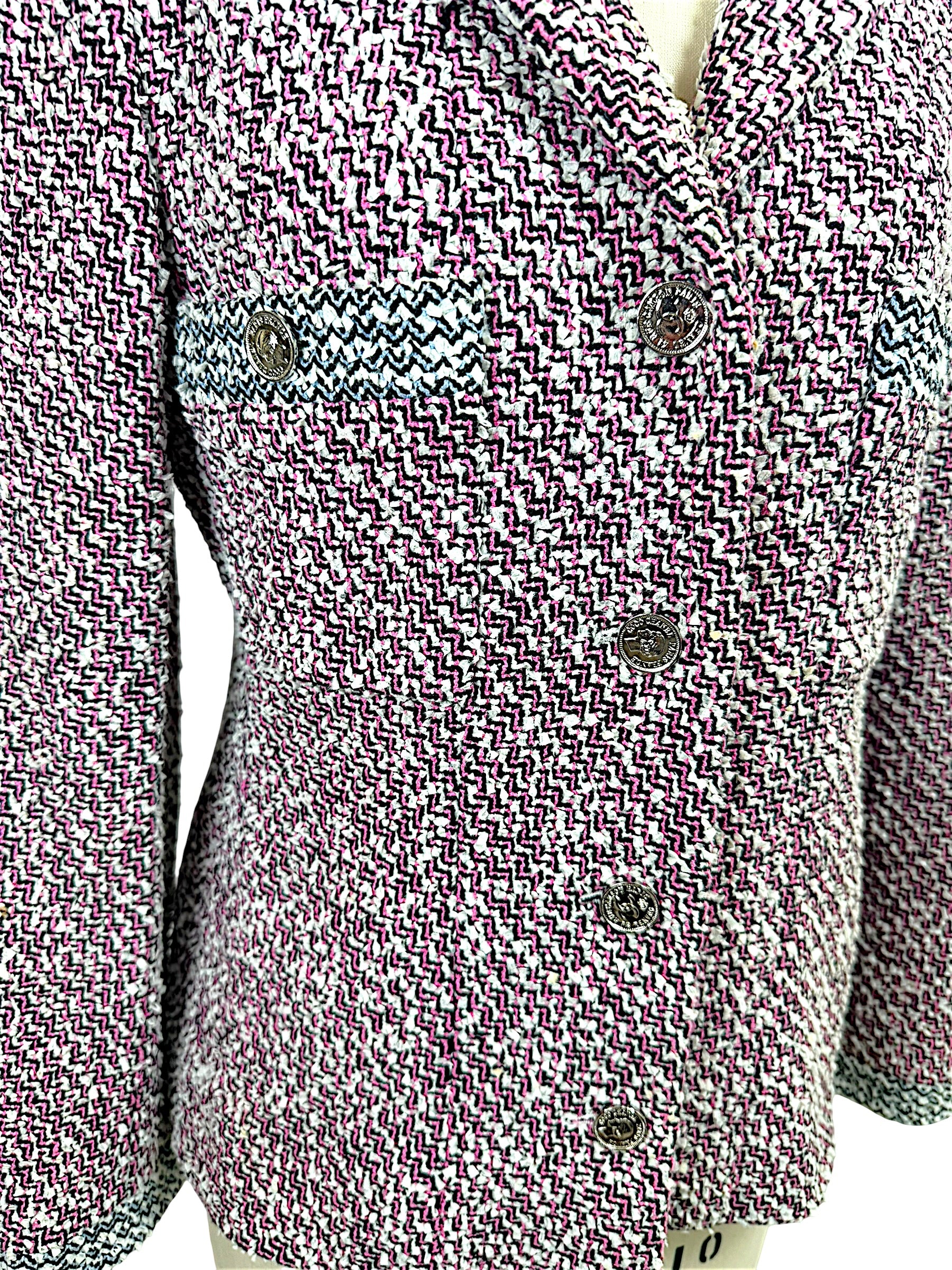 Detailed view of Chanel Spring 1996 tweed jacket showing signature CC medallion buttons and textured woven fabric